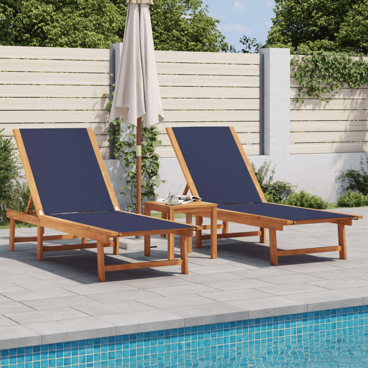 Due lettini blu imbottiti a bordo piscina con tavolino e ombrellone in un giardino.
