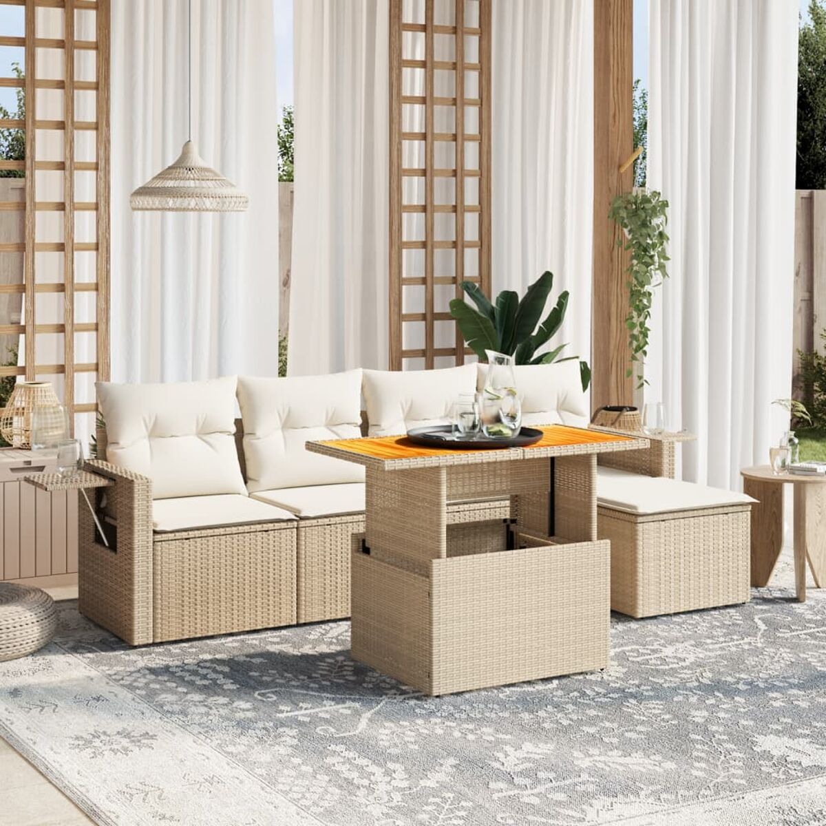 Set da esterno con divano, tavolo e pouf su un tappeto.