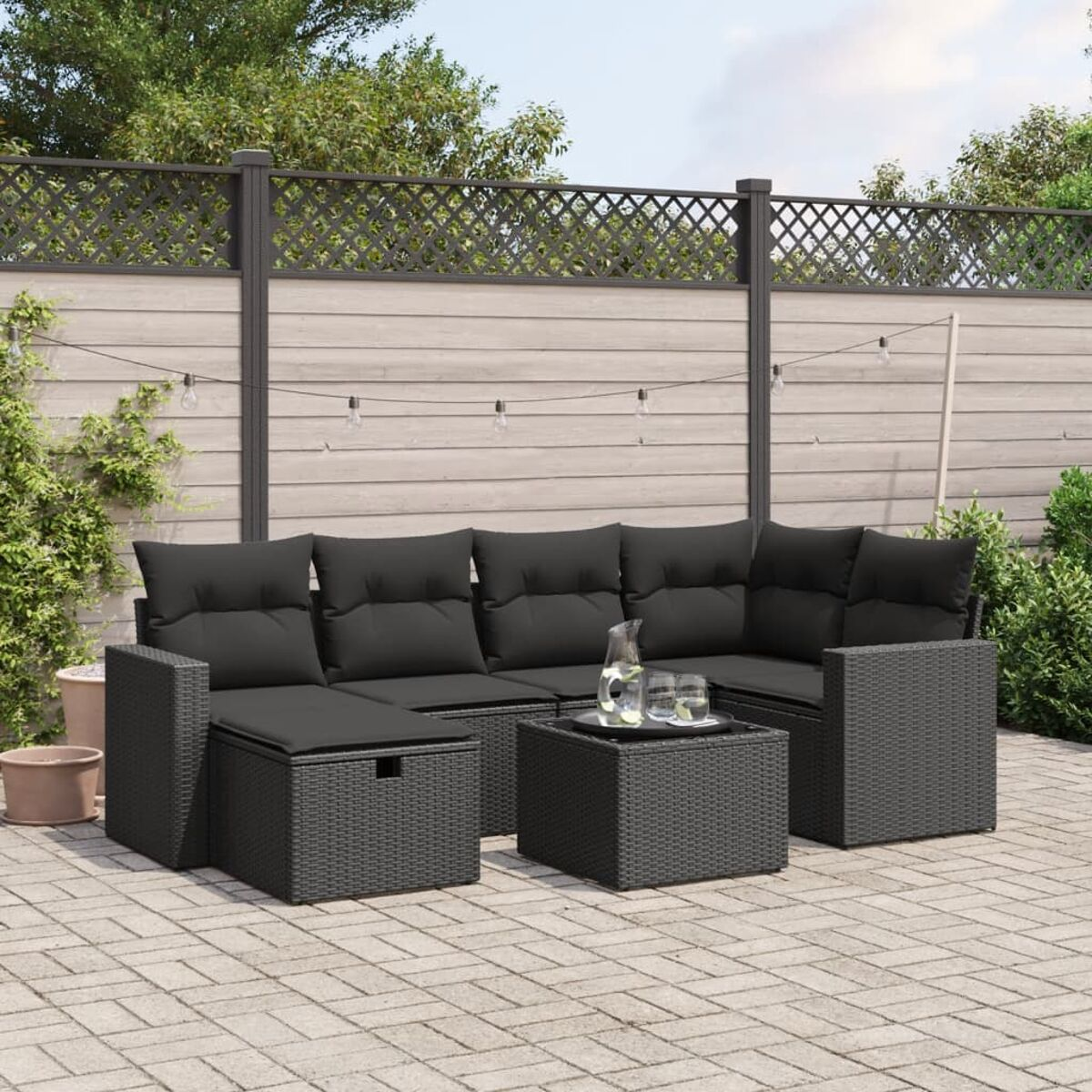 Ein schwarzes Outdoor-Set aus Korbgeflecht mit Kissen, Sofa und Tisch.