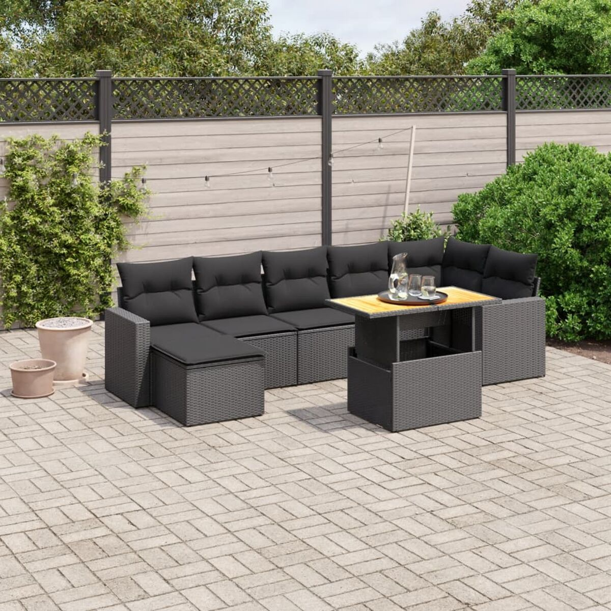 Outdoor-Ecksofa mit schwarzen Kissen und Couchtisch mit Hubtisch.