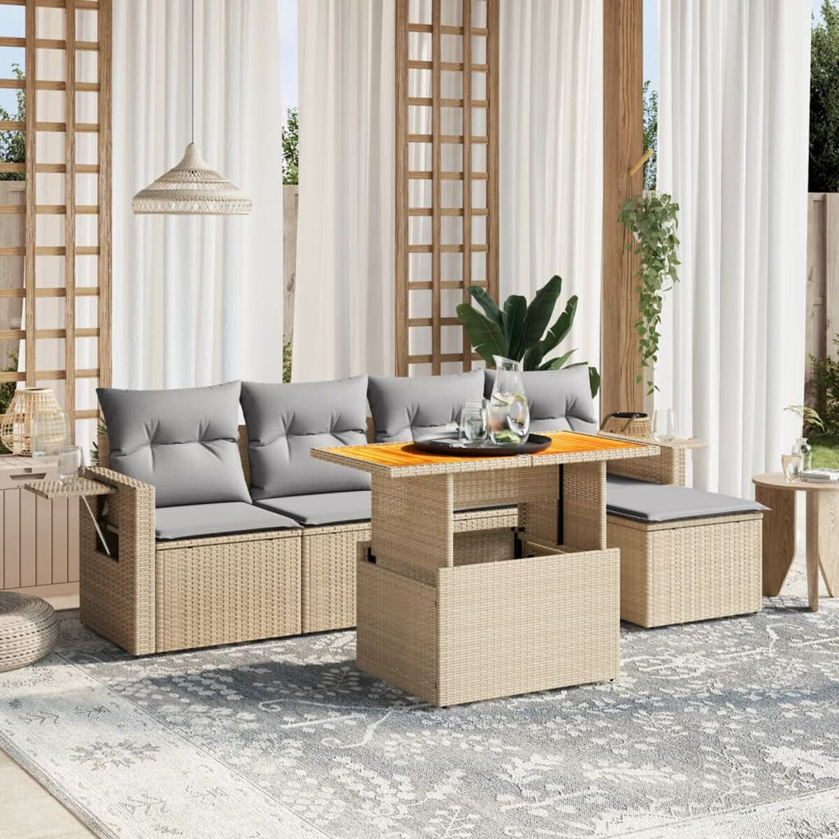 Terrassenmöbel-Set mit Tisch, Sofa und Ottomane auf einem Teppich.