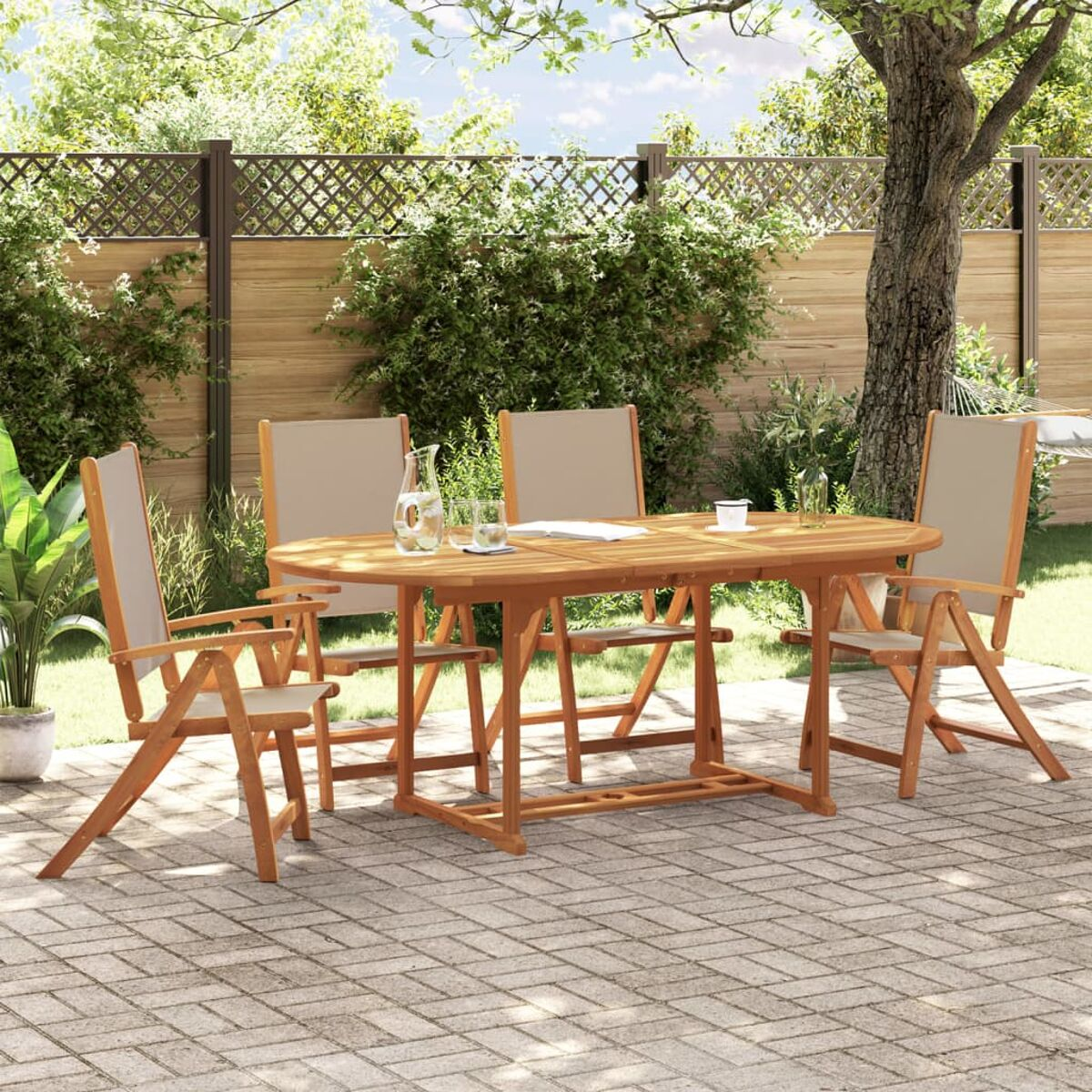 Set da pranzo in legno per esterni in giardino. Tavolo con quattro sedie. Alberi verdi ed erba sullo sfondo.