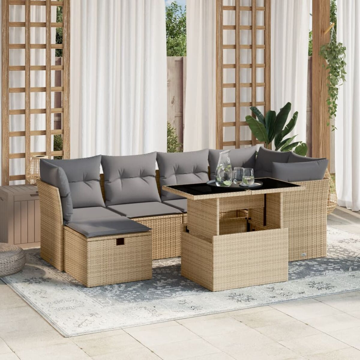 Outdoor-Ecksofa aus Korbgeflecht mit einem Couchtisch mit Hubtischplatte. Graue Kissen. Terrasse.