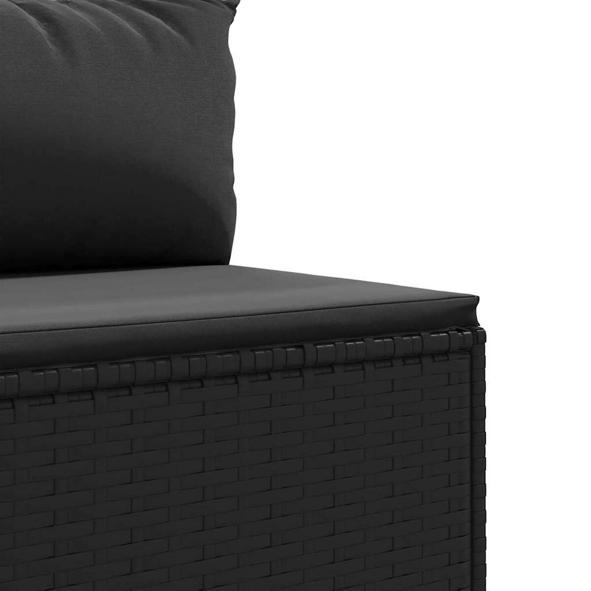 Primer plano de muebles de exterior negros de mimbre con cojín gris. La textura del mimbre es visible.