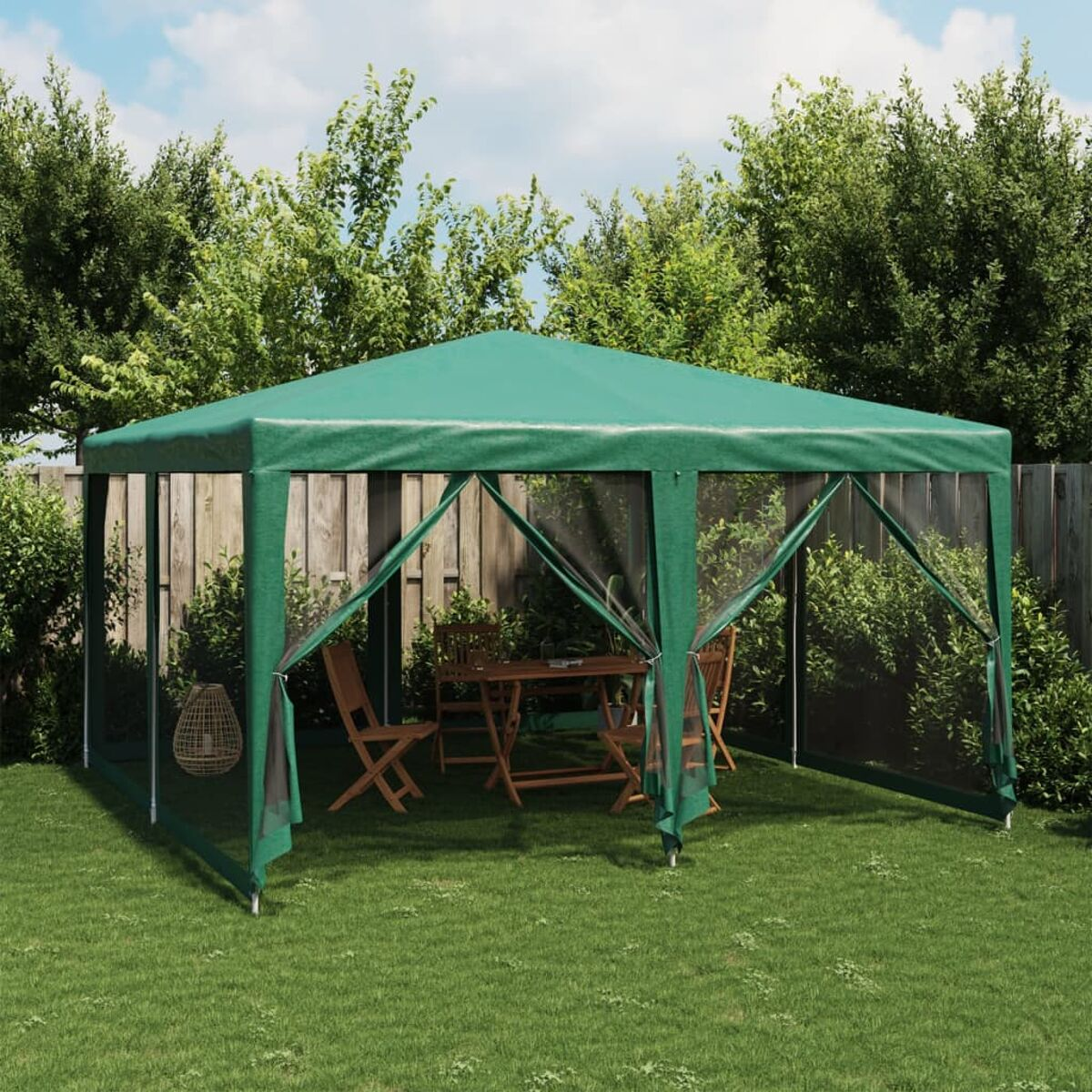 Gazebo verde con lati in rete in un giardino. Tavolo e sedie all'interno.