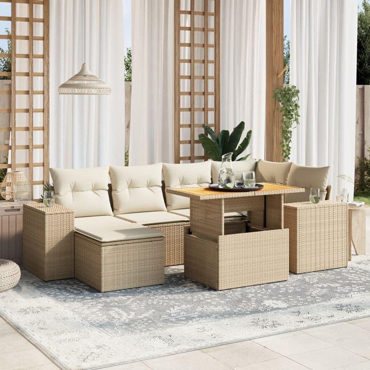Beiges Outdoor-Wicker-Sofaset mit cremefarbenen Kissen, Couchtisch und Deko-Artikeln auf einem Teppich.