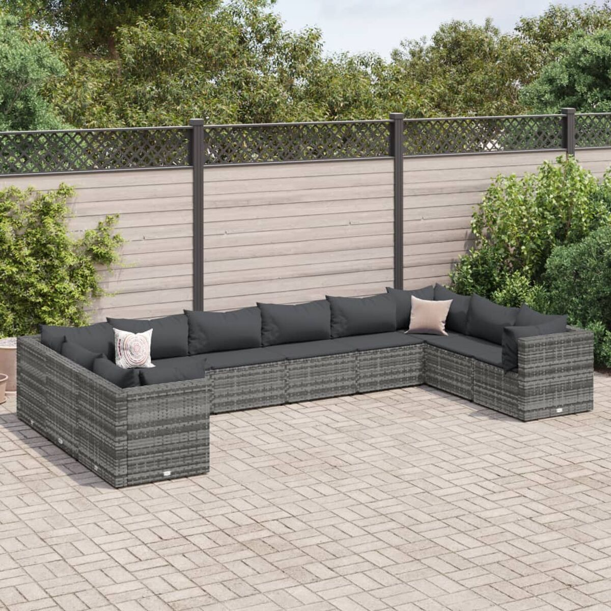 Graues Korbgeflecht-Gartenmöbel-Set. Enthält ein Sofa und ein Ecksofa mit grauen Kissen und Kissen.