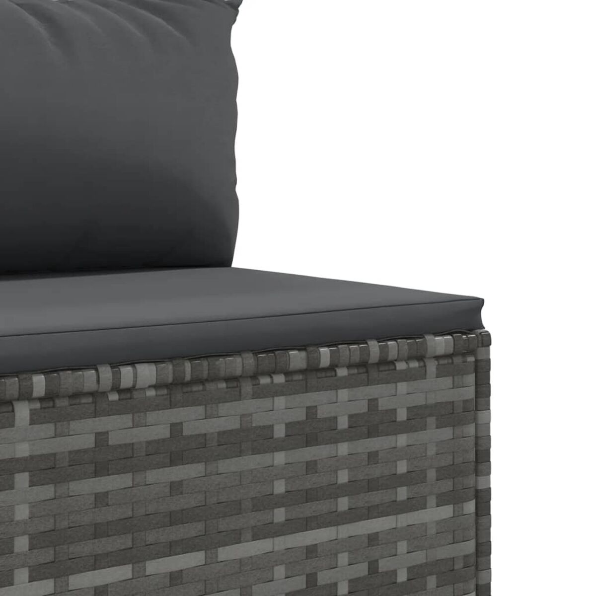 Nahaufnahme der Ecke eines grauen Rattan-Sofas mit einem dunkelgrauen Kissen.