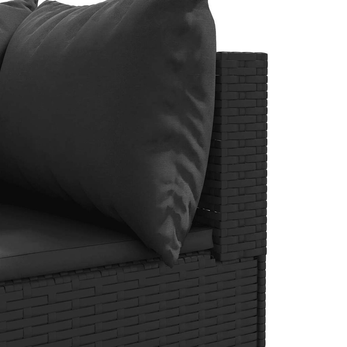 Primer plano del reposabrazos y cojín de una silla de mimbre negra. Se ven colores oscuros y textura.