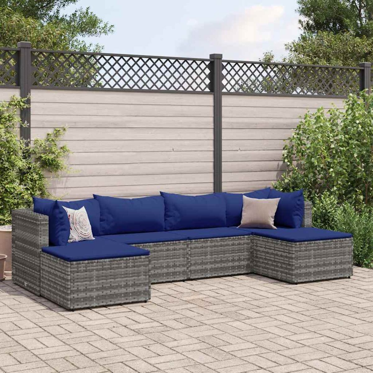 U-förmiges Outdoor-Ecksofa mit marineblauen Kissen auf einer Terrasse. Grauer Korbrahmen.