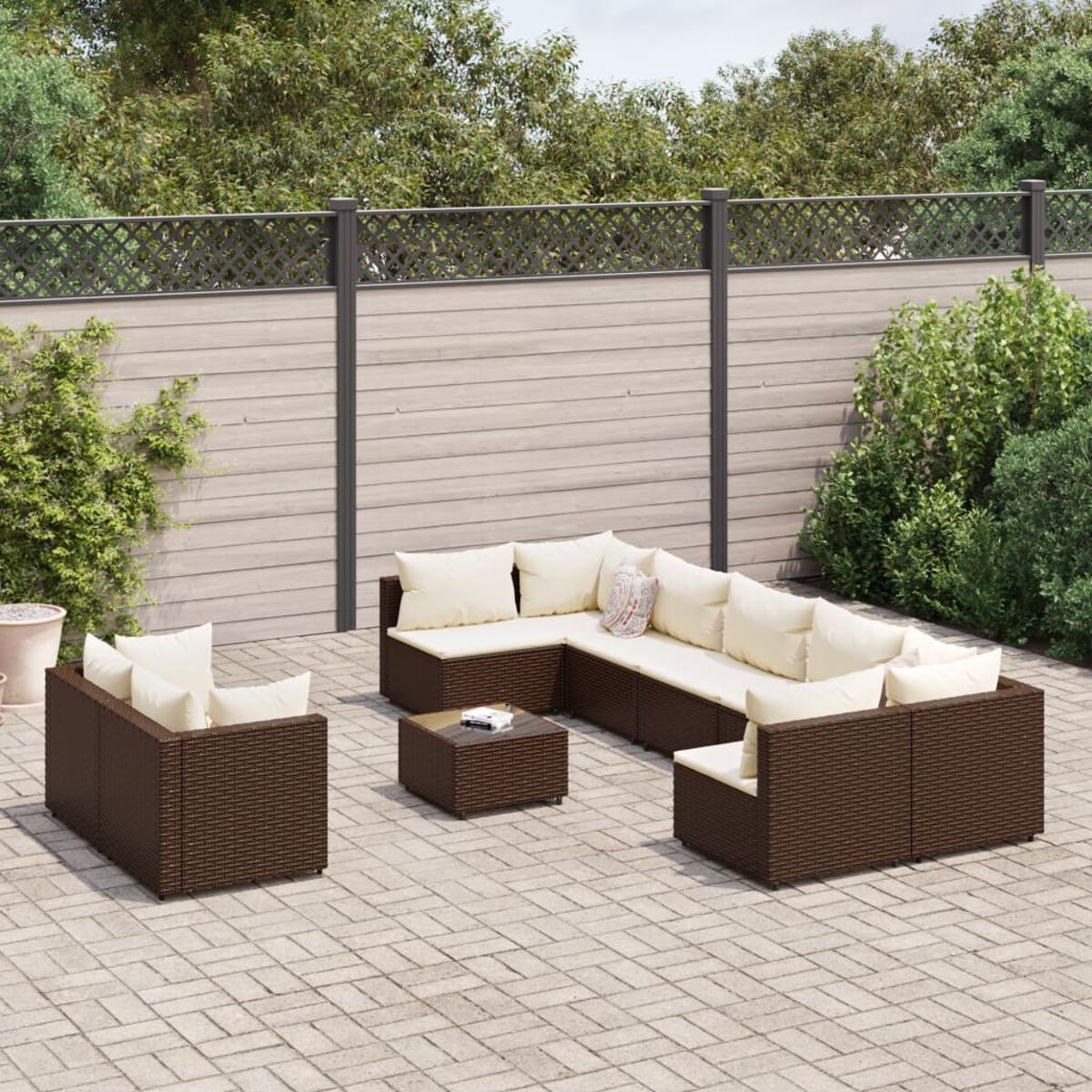 Geflochtenes Ecksofa-Set mit Tisch und cremefarbenen Kissen. Das Set ist draußen.