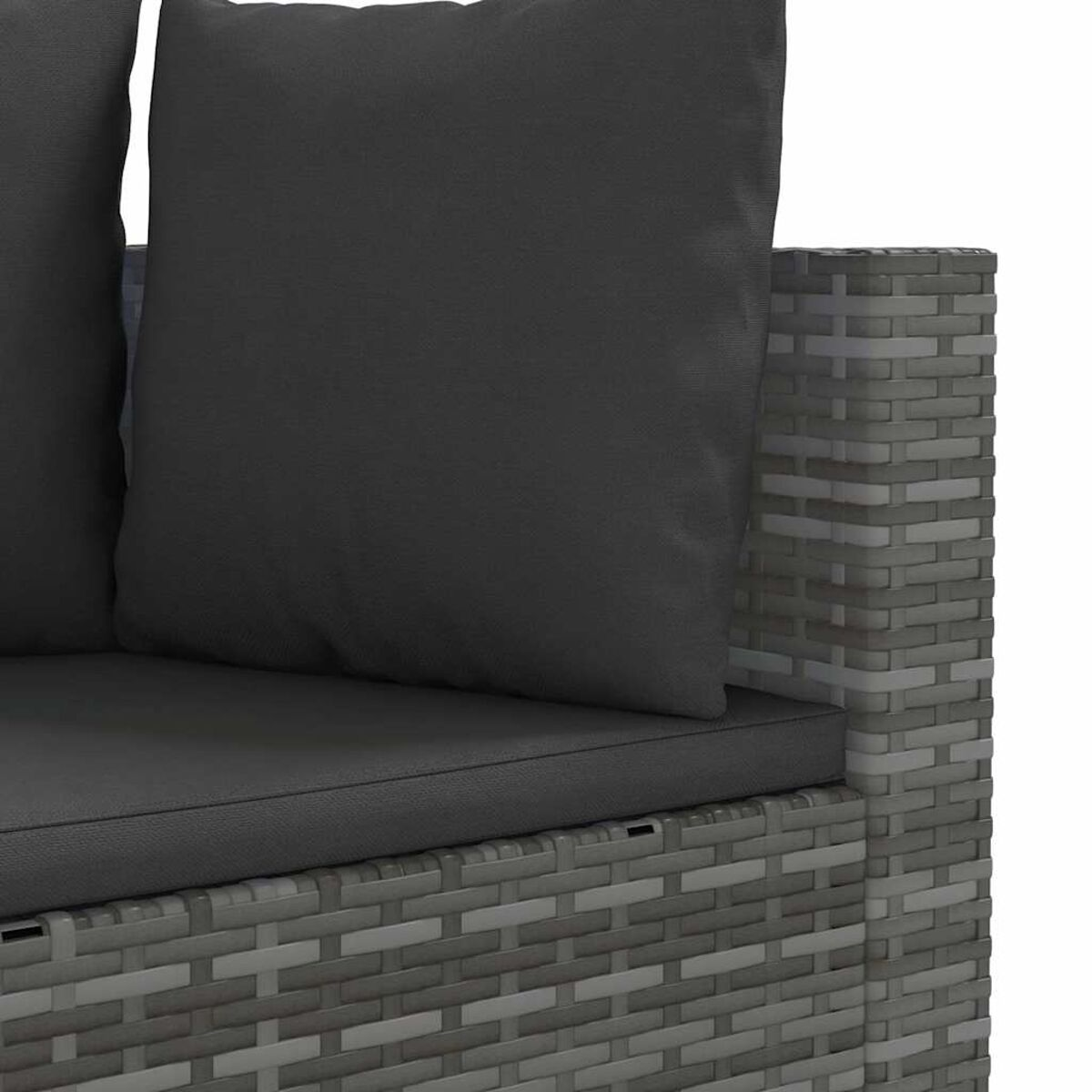 Nahaufnahme eines grauen Korbmöbelsofas mit dunkelgrauen Kissen. Der Hintergrund ist weiß.