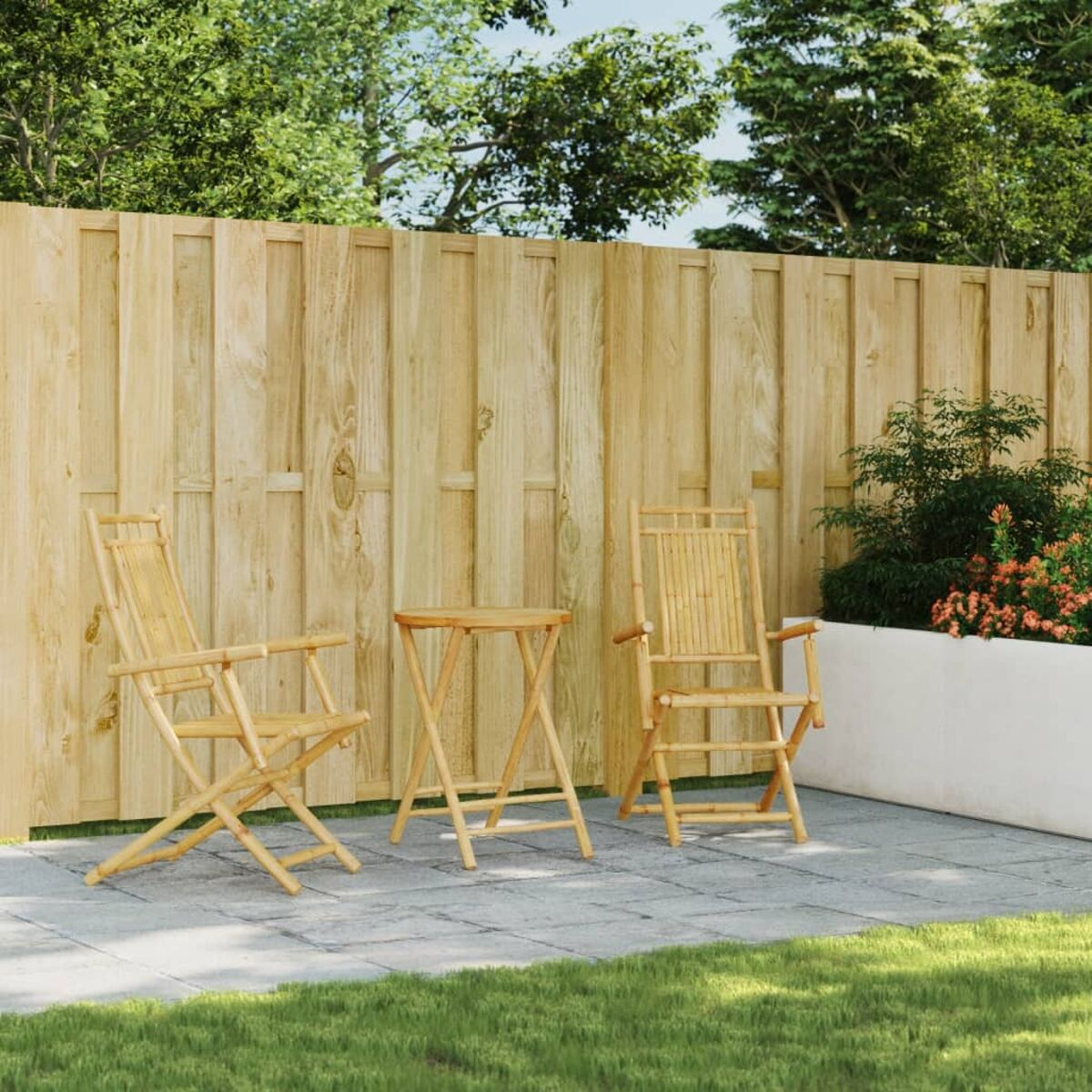 Zwei Bambus-Klappstühle und ein kleiner Tisch auf einer Terrasse. Grünes Gras und Holzzaun.