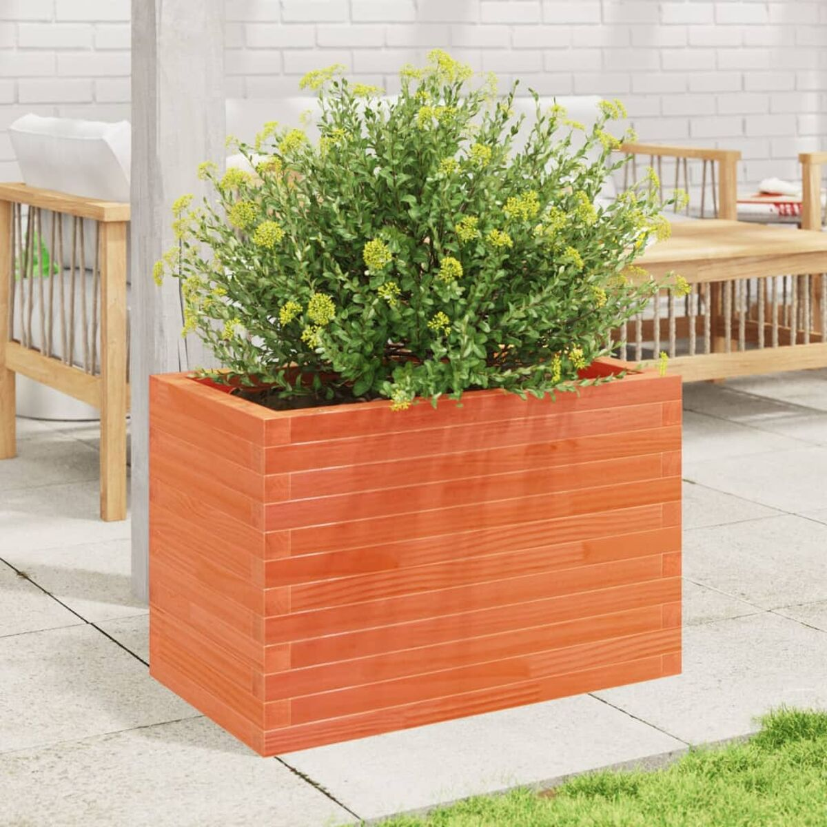 Ein orangefarbener Holzpflanzer mit einer grünen Pflanze auf einer Terrasse.