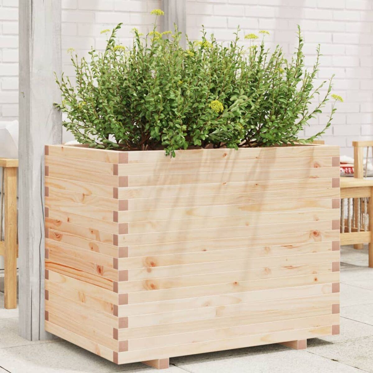 Holzpflanzkasten mit Pflanzen. Die Box hat eine quadratische Form und steht auf einer Fliesenoberfläche.
