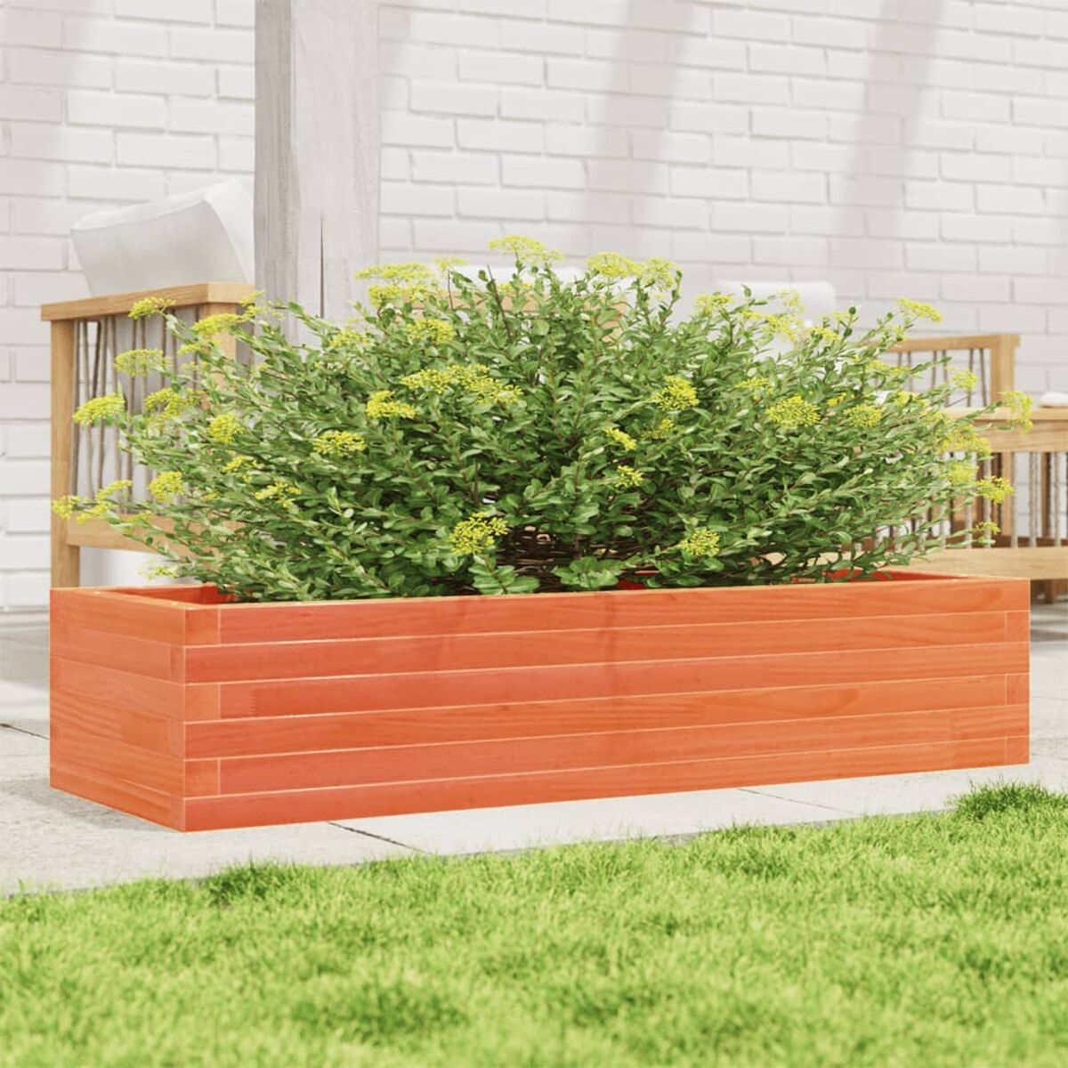 Holz-Pflanzkasten mit grünen Pflanzen, auf einer Terrasse platziert.