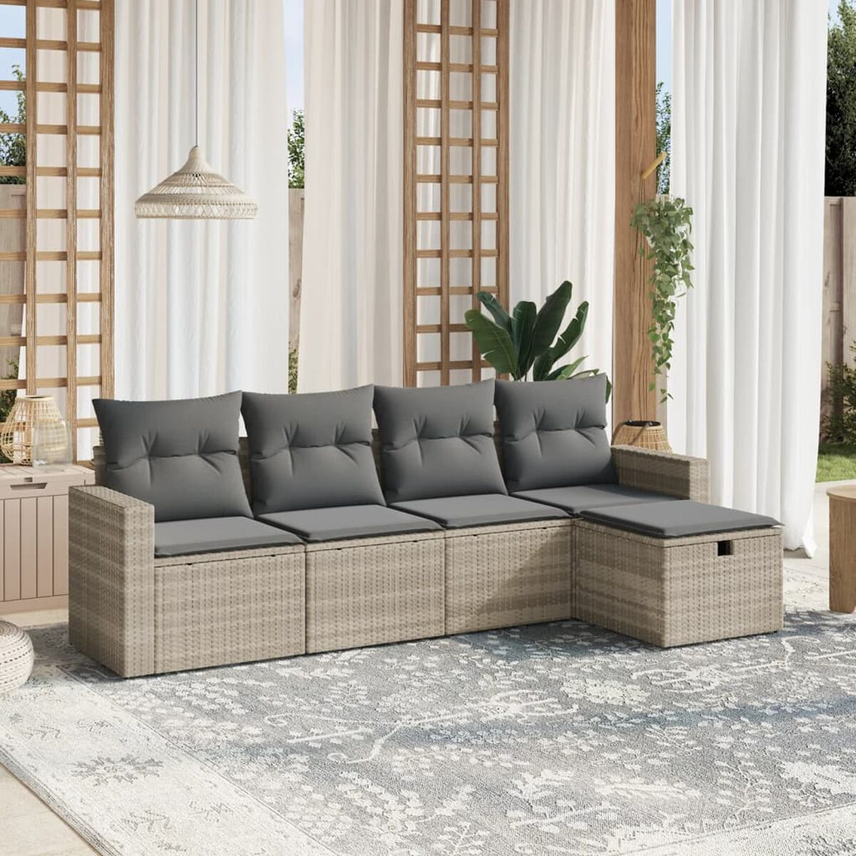 Beiges Rattansofa mit grauen Kissen. Außenbereich mit durchsichtigen Vorhängen und Pflanzen.