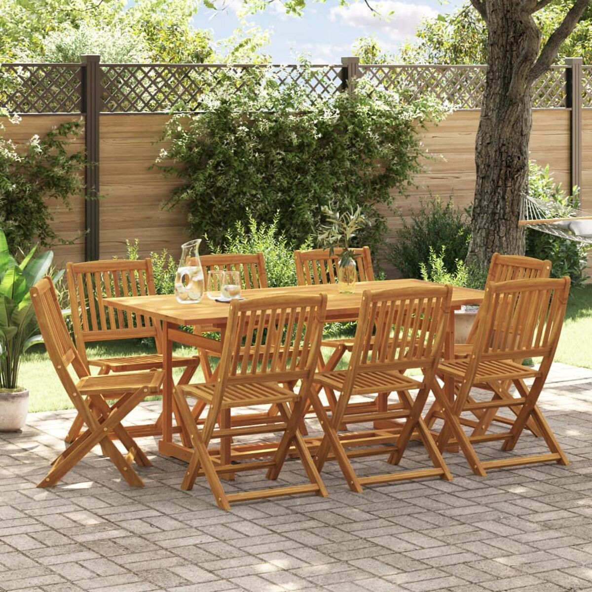 Set tavolo e sedie in legno in un giardino, con patio in mattoni e alberi.