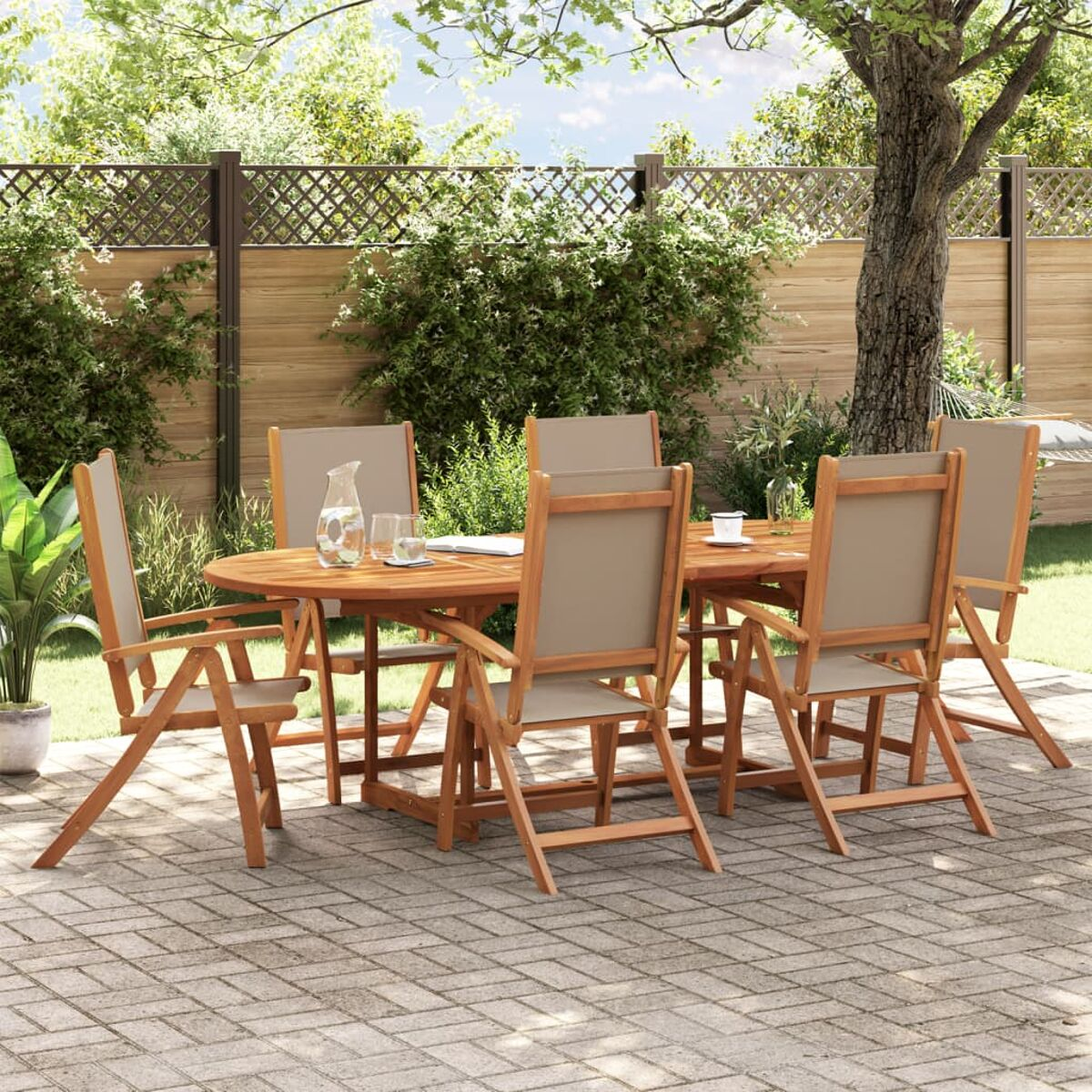 Tavolo e sedie in legno su un patio. C'è una recinzione e degli alberi sullo sfondo.