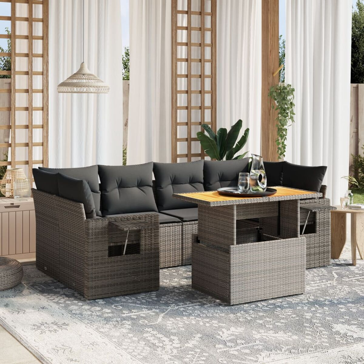 Graues Outdoor-Ecksofa aus Korbgeflecht mit einem Tisch mit Hubfunktion und einem Teppich.