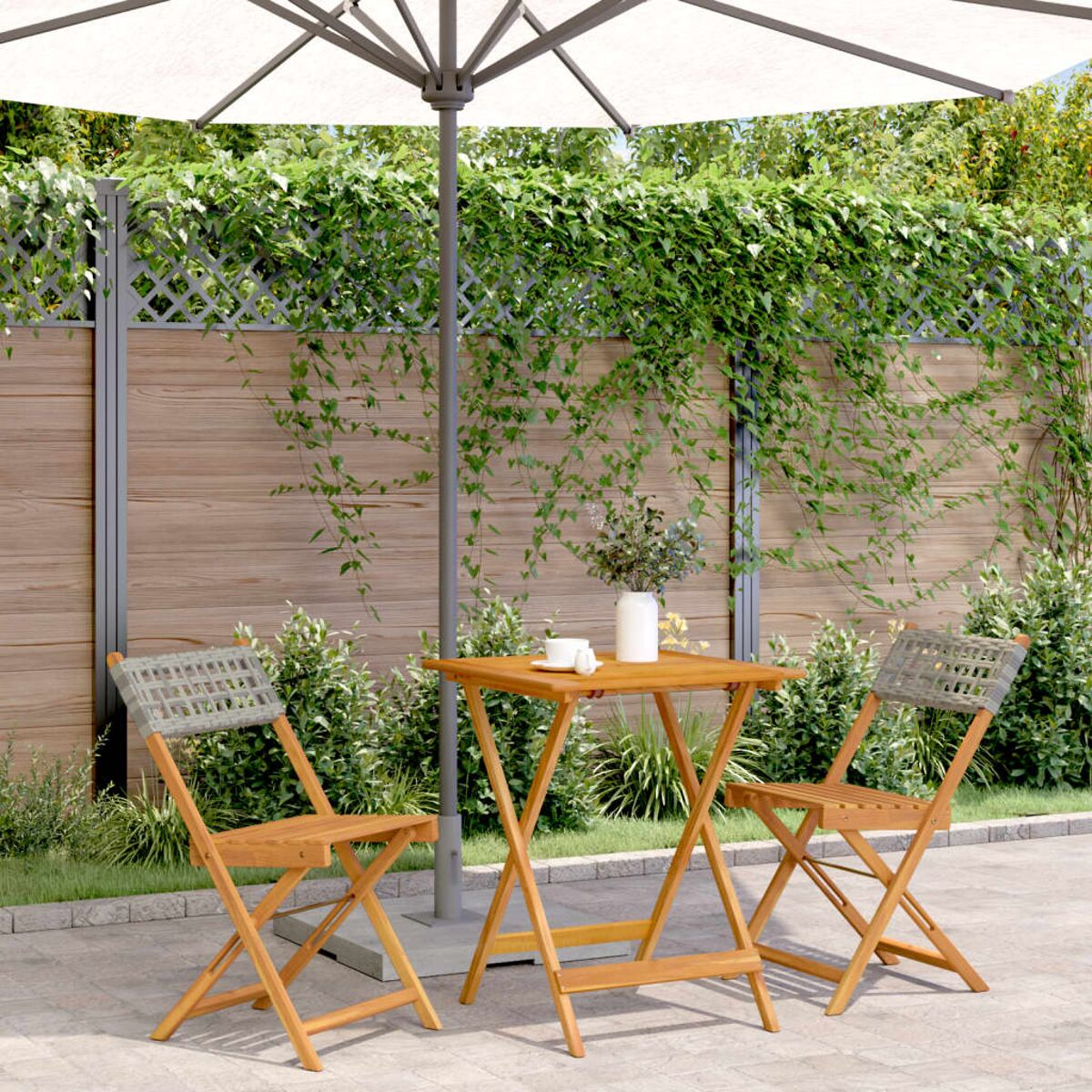 Terrassenset mit Tisch, zwei Stühlen und Sonnenschirm.