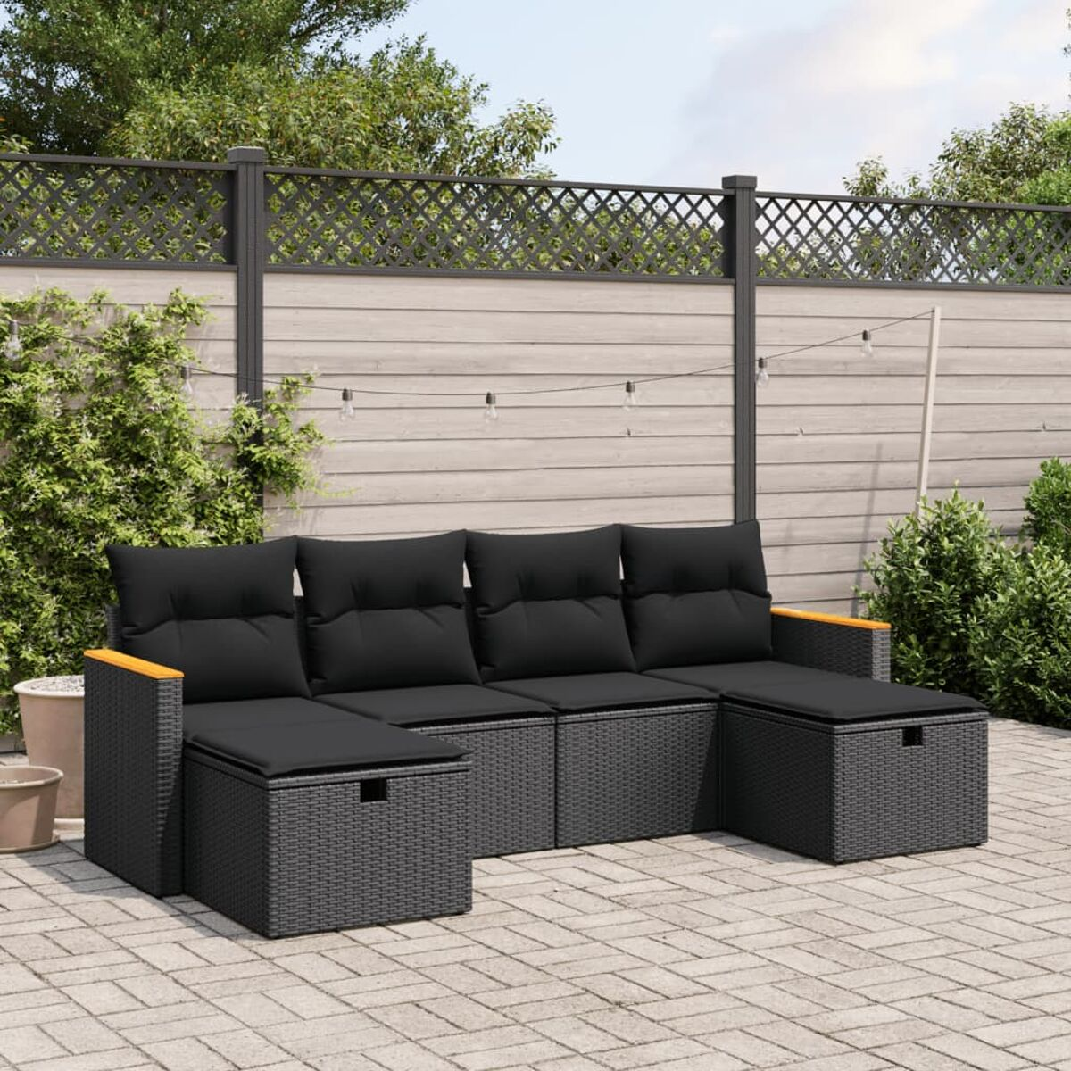 Schwarzes Rattan-Sofa-Set mit schwarzen Kissen und Holzarmlehnen.