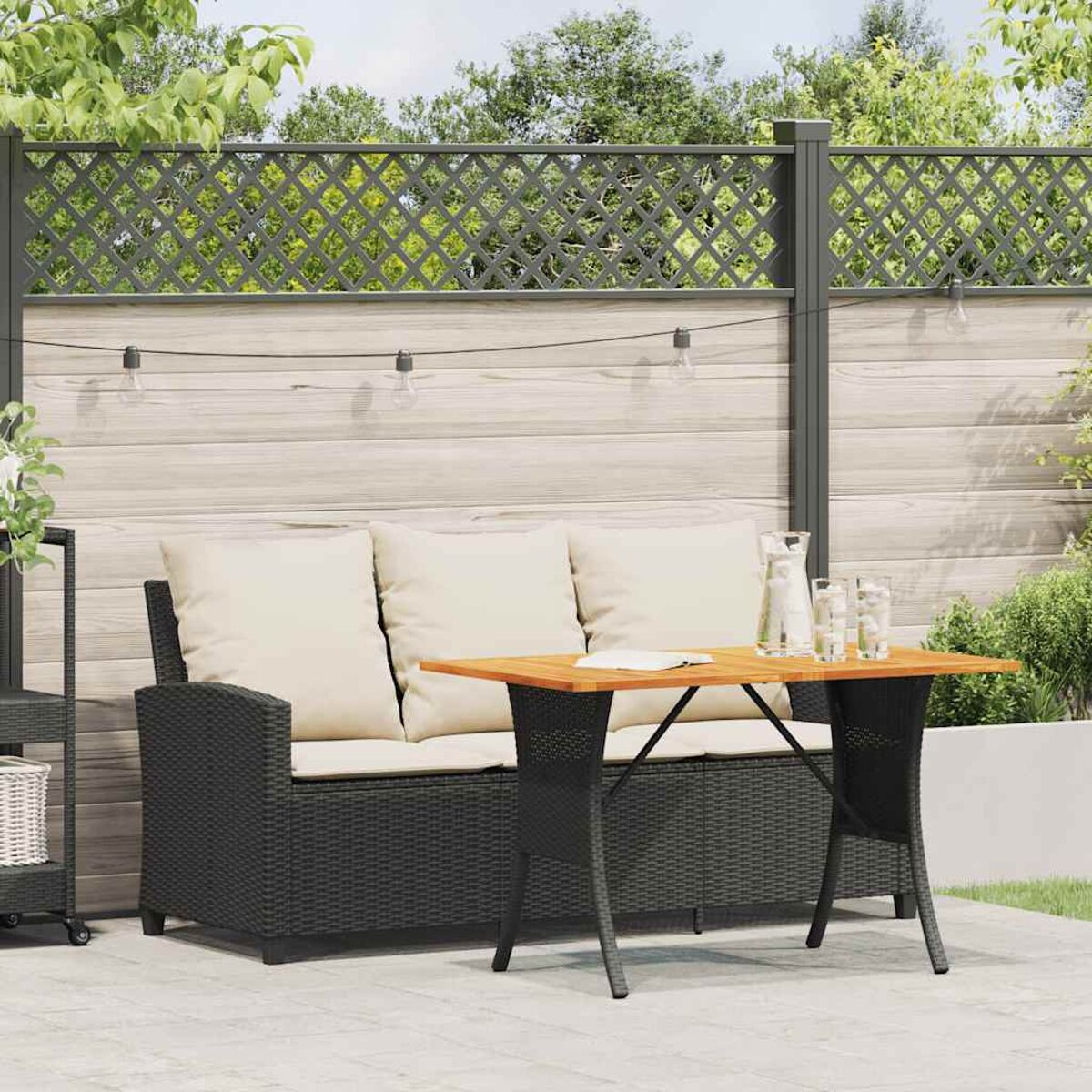 Terrassen-Set für den Außenbereich mit Sofa, Tisch und zwei Stühlen. Der Hintergrund hat einen Zaun und Pflanzen.
