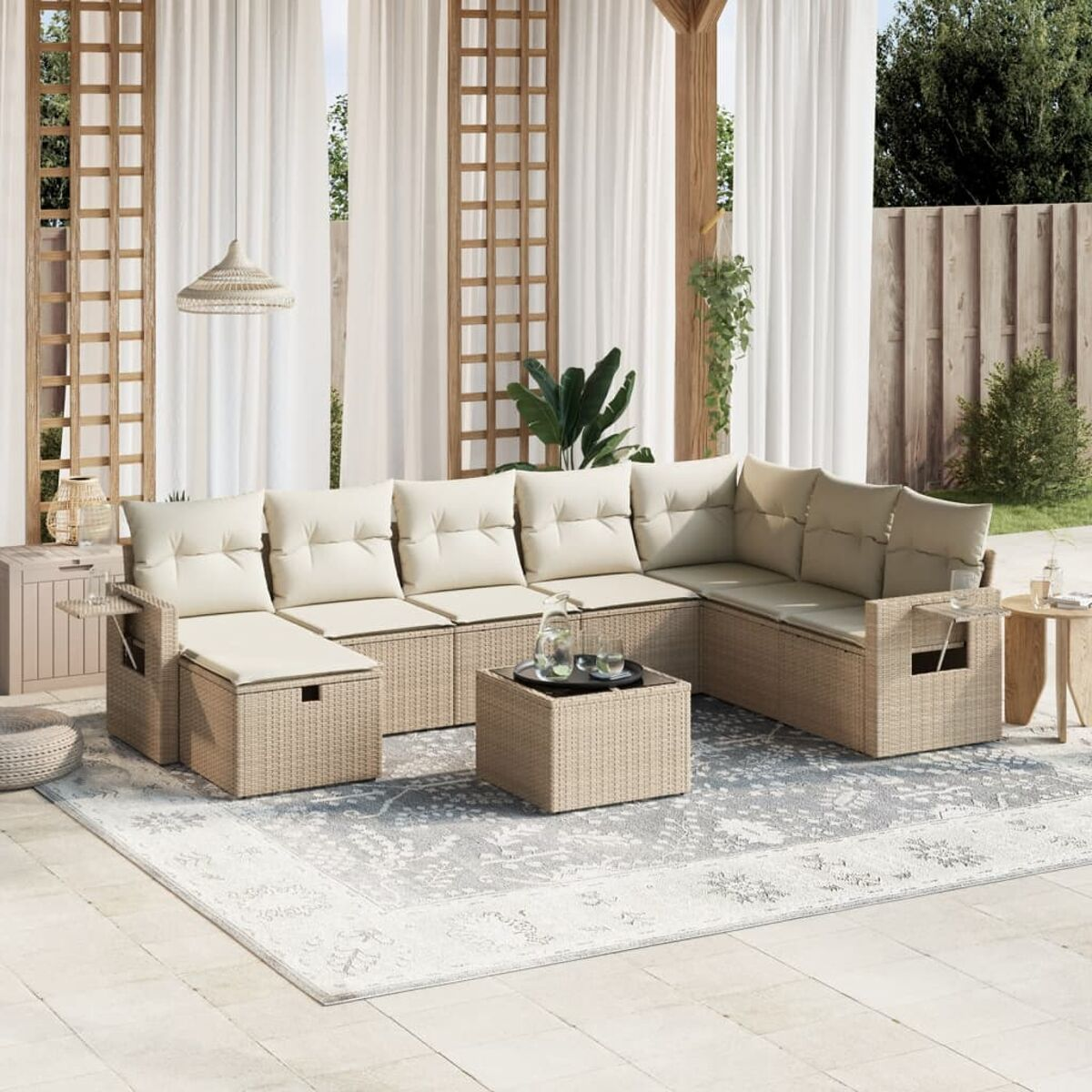Outdoor-Ecksofa-Set. Beige Kissen und ein korbartiges Gestell. Auf einer Terrasse mit Teppich, Pflanzen und Vorhängen.