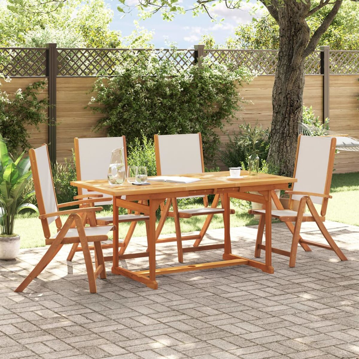 Set da pranzo in legno per esterni con tavolo e quattro sedie, su un'area pavimentata, con alberi.