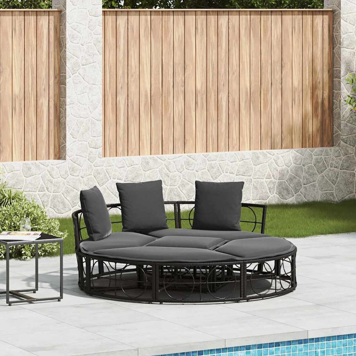 Rundes schwarzes Outdoor-Tagesbett mit Kissen. Umgebung am Pool, stilvoll.