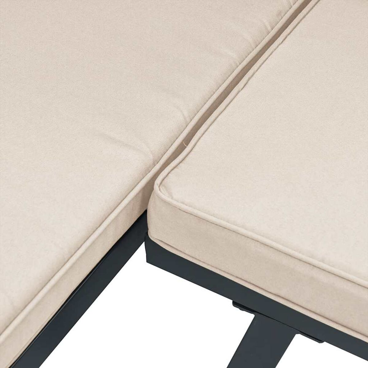 Nahaufnahme von beigen Kissen auf einem schwarzen Rahmen-Sofa.
