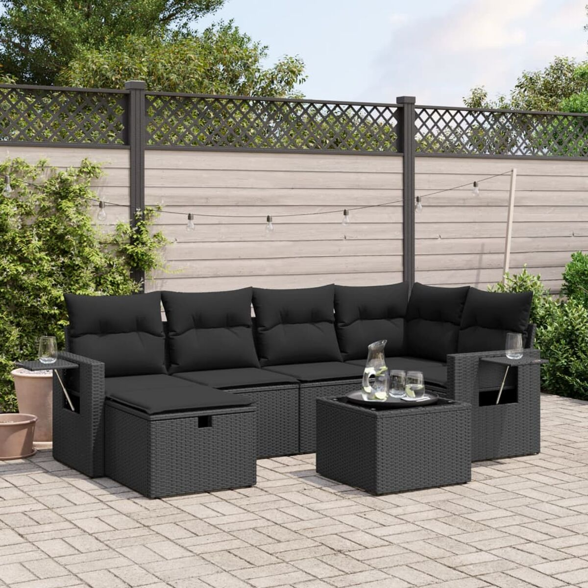 Schwarzes Outdoor-Sofa aus Korbgeflecht mit Kissen, Couchtisch und Beistelltischen. Patio-Setting.
