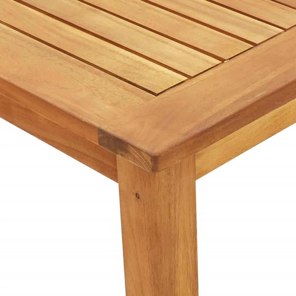 Nahaufnahme einer Holztischecke. Das Holz hat eine hellbraune Farbe.