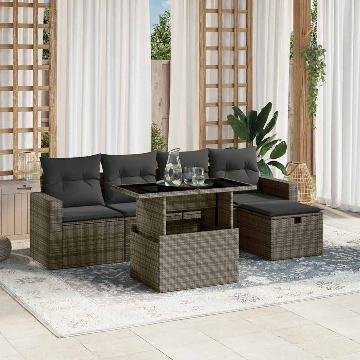 Rattan-Sofa mit schwarzem Tisch. Schwarze Kissen und ein Teppich. Weiße Vorhänge im Hintergrund.