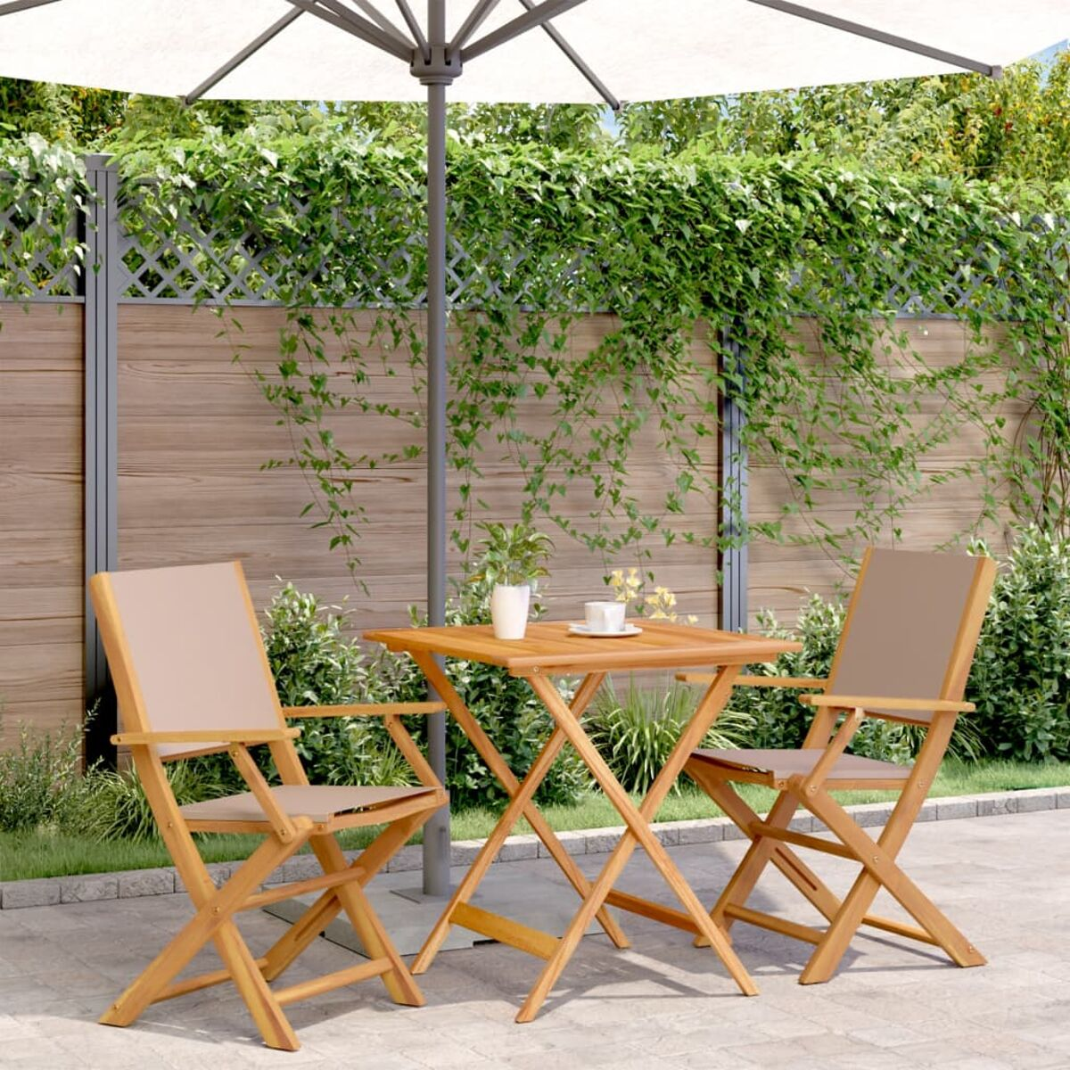Gartenmöbel mit zwei Stühlen und einem Tisch. Mit Sonnenschirm, Pflanzen und Holzzaun.