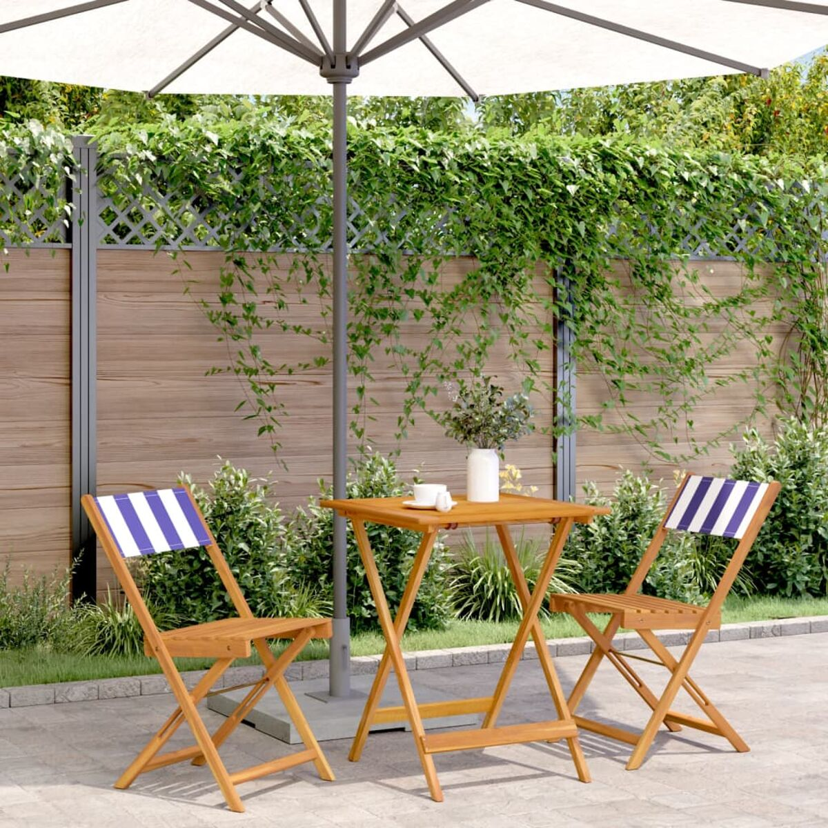 Ein Outdoor-Terrassenset mit Tisch, zwei Stühlen und einem Sonnenschirm.
