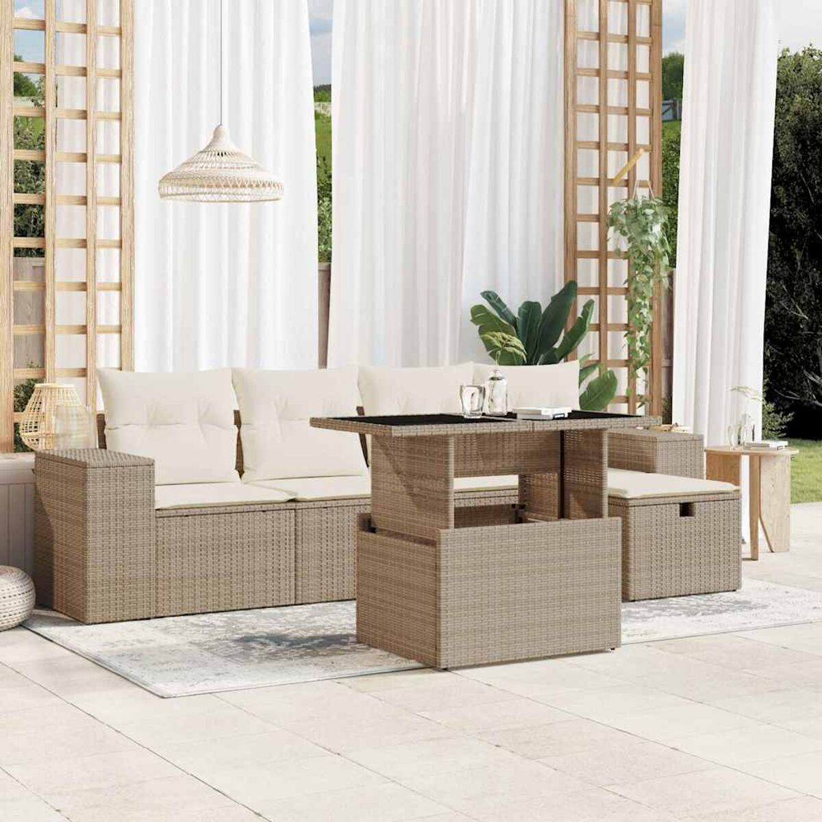 Divano componibile da esterno beige con cuscini color crema e tavolo elevabile. Tende bianche dietro.