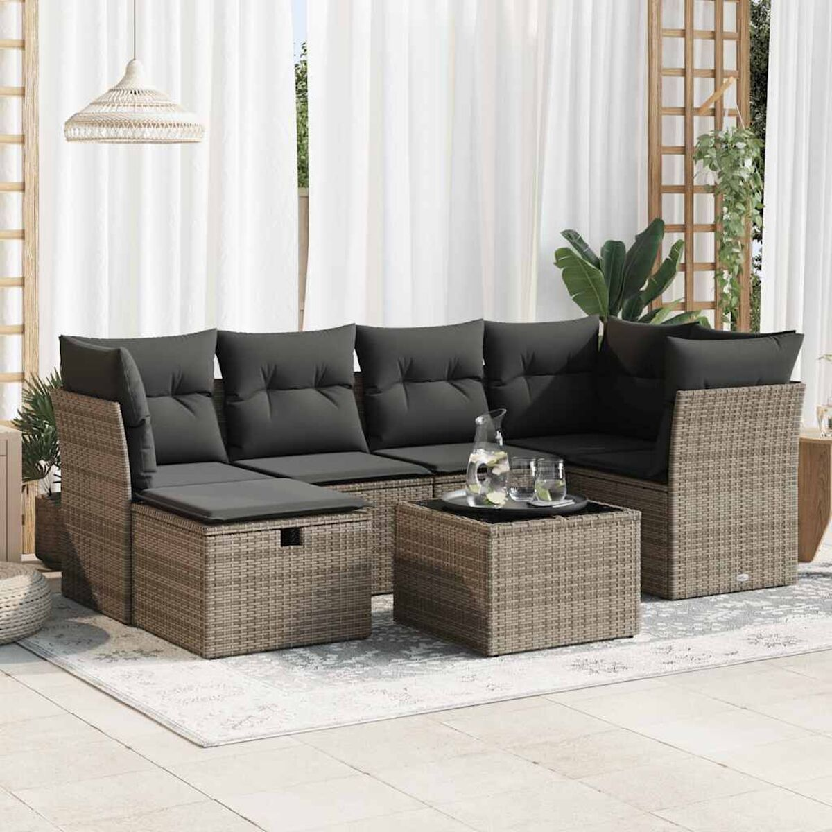 Outdoor-Set: graues Sofa, Couchtisch und Zubehör auf dem Teppich.