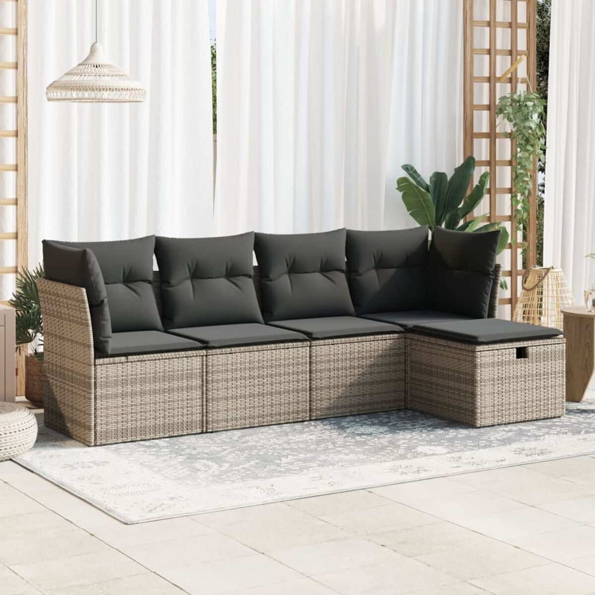 Beiges Outdoor-Sofa aus Korbgeflecht mit grauen Kissen und einem weißen Teppich.