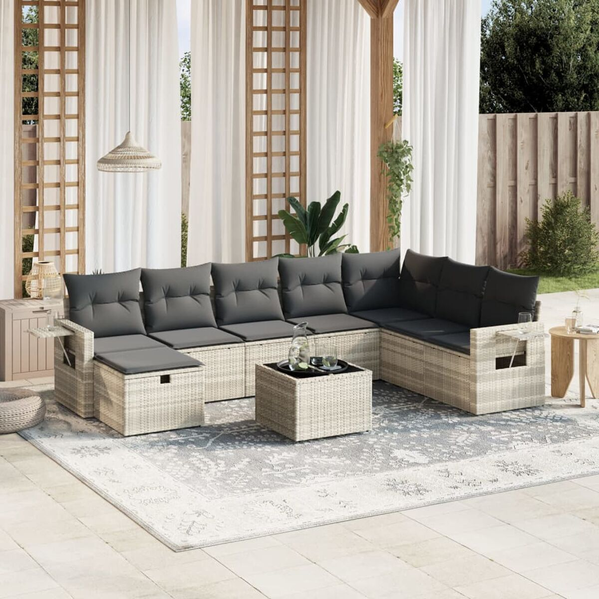 Geflochtenes Outdoor-Ecksofa-Set mit grauen Kissen und Couchtisch auf gemustertem Teppich.