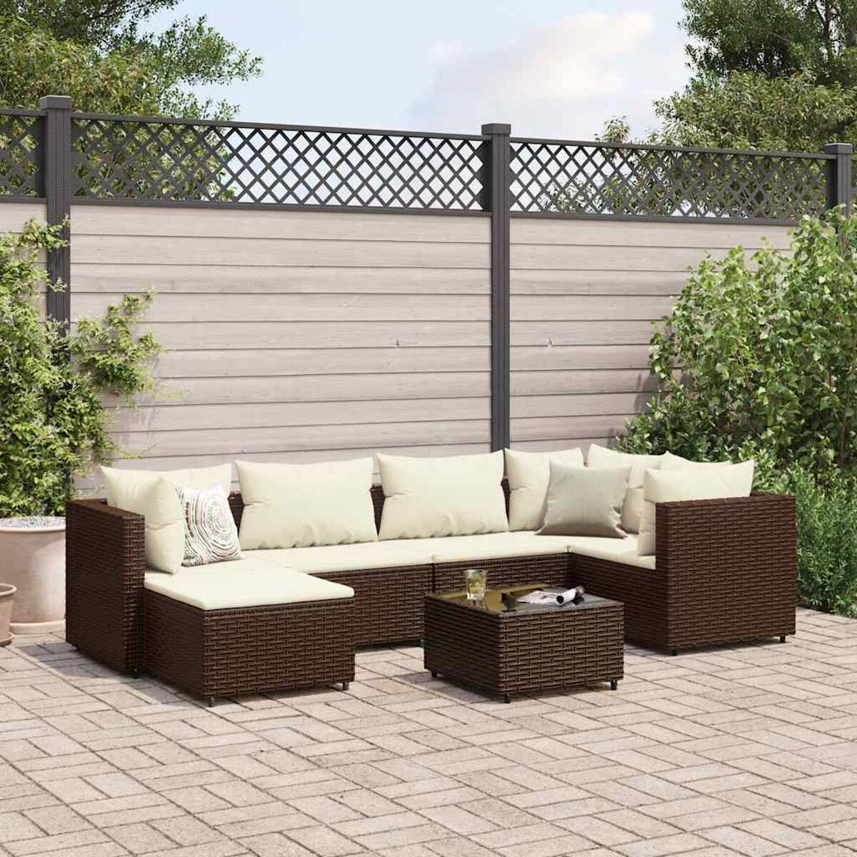 Set patio esterno con divano componibile e tavolo. Mobili in rattan marrone. Patio in mattoni.