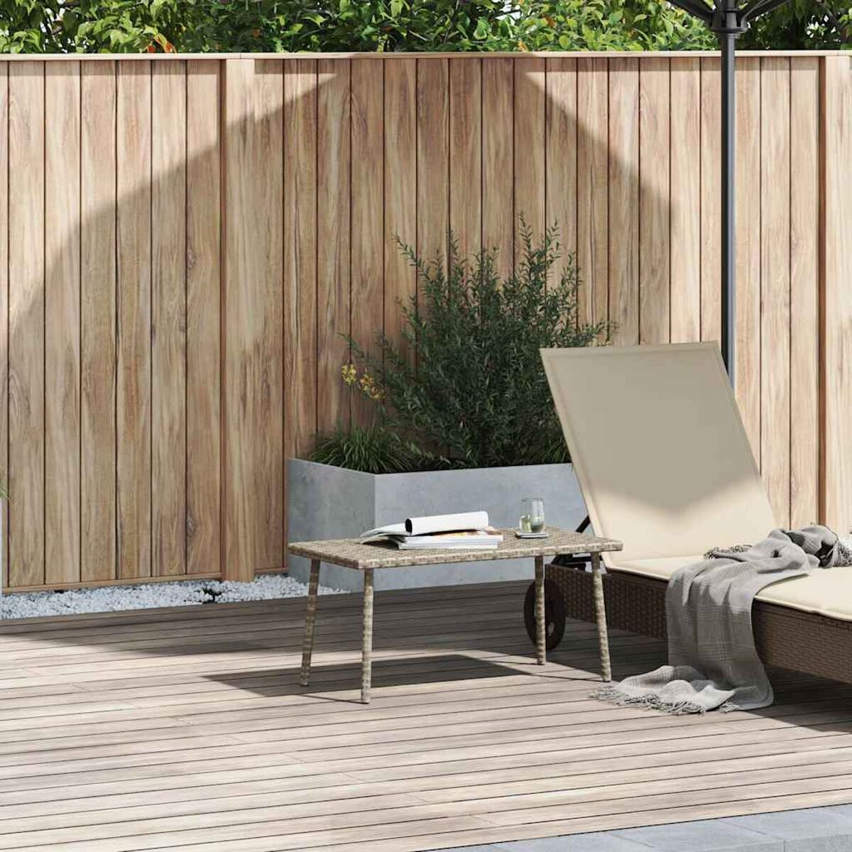 Holzdeck mit Holzzaun, Tisch, Sonnenliege und Pflanze.