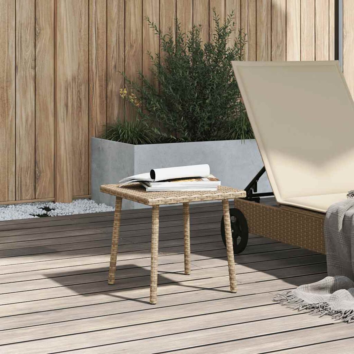 Ein kleiner Holztisch mit einem Buch darauf. Ein Strandstuhl dahinter. Holzwand und Pflanze im Hintergrund.