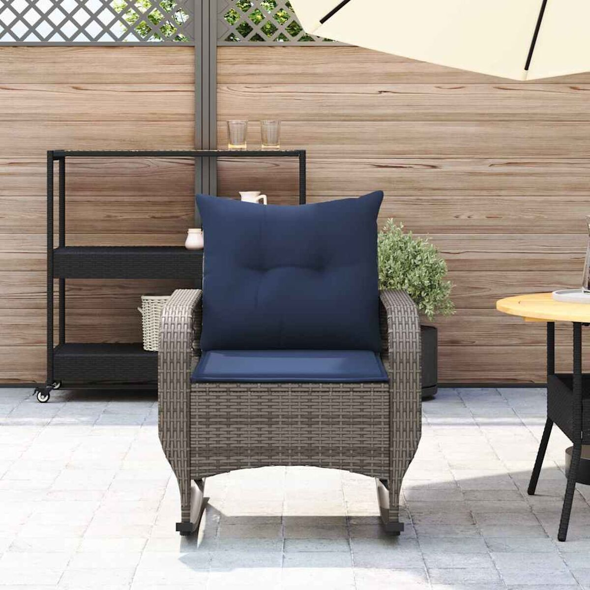 Sedia in vimini con cuscino blu scuro, ambiente esterno con tavolo.