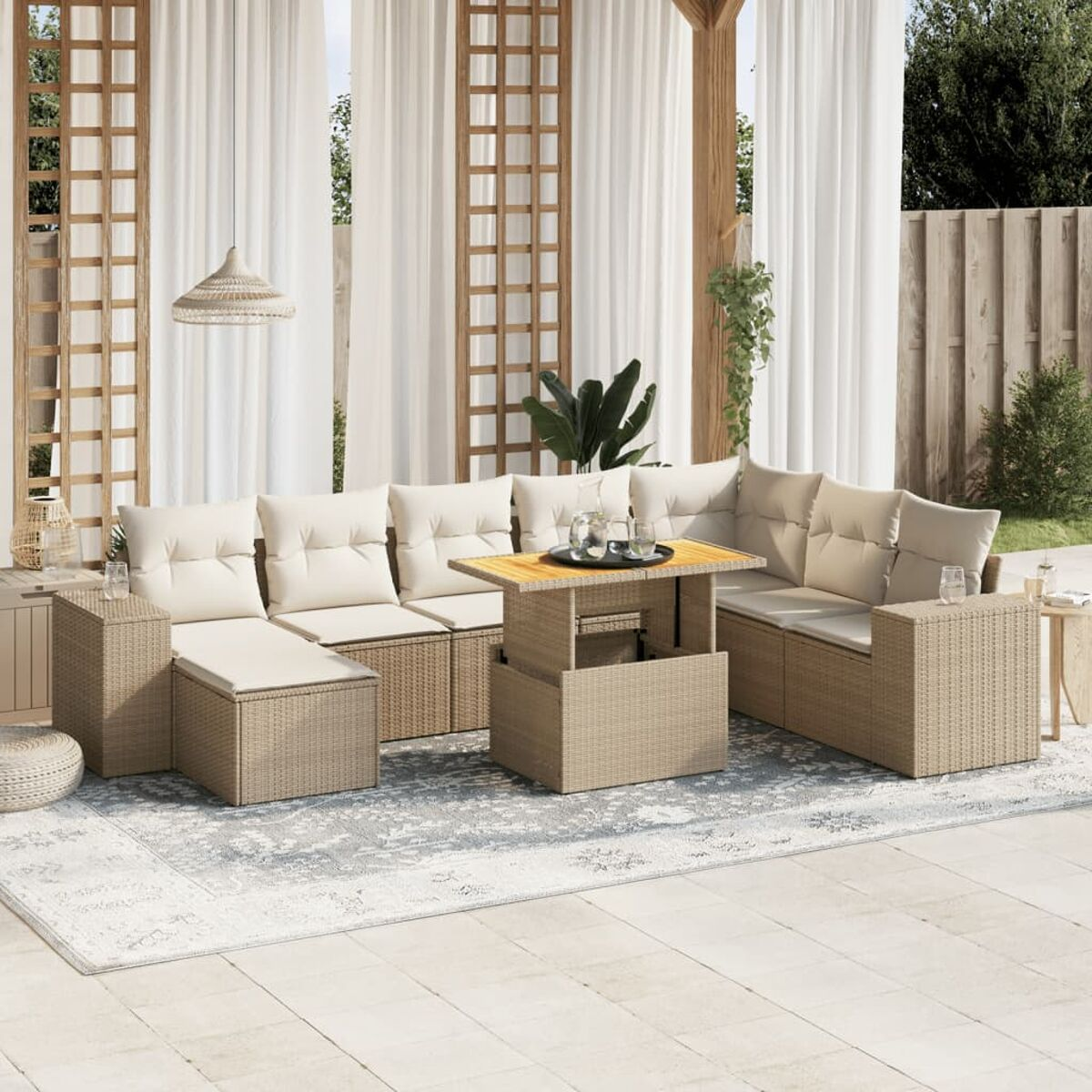 Set da patio all'aperto con cuscini beige, tavolo in legno e tende sullo sfondo.