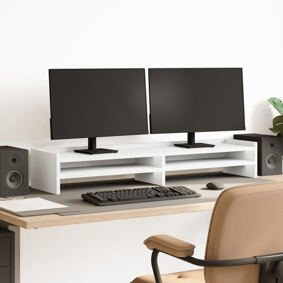 Ein Schreibtisch mit Monitoren, Lautsprechern, einer Tastatur, einer Maus und einem Stuhl.