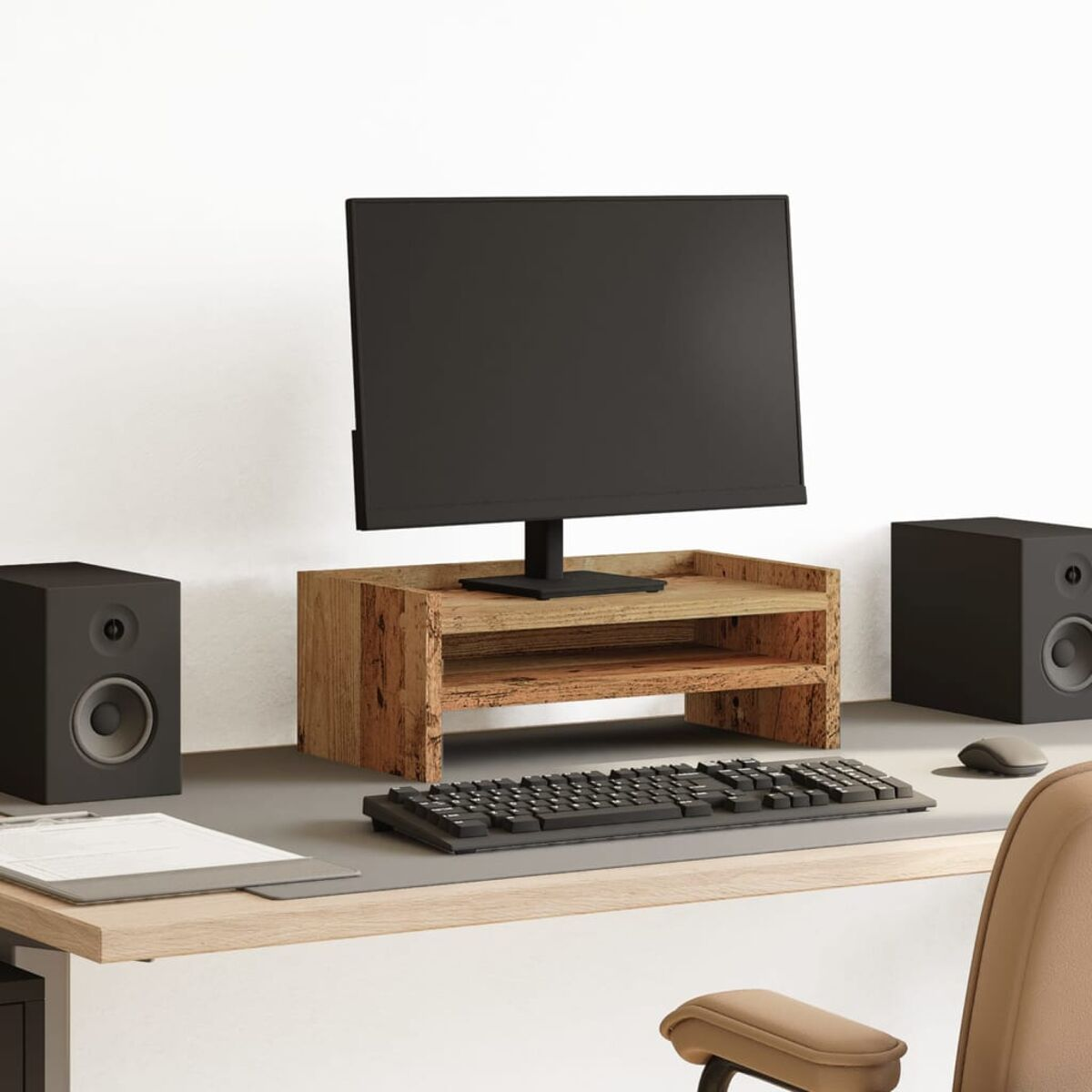 Ein Schreibtisch-Setup mit Monitor, Lautsprechern, Tastatur, Maus und einem Holzständer auf einem grauen Schreibtischpad.