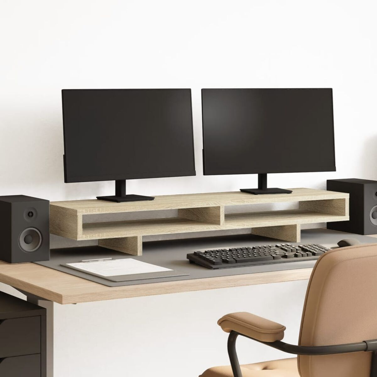 Ein Schreibtisch mit zwei Monitoren, Lautsprechern, Tastatur und Bürostuhl.