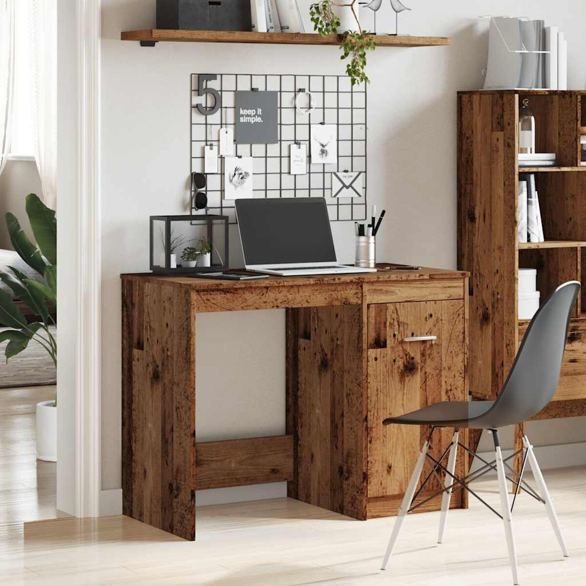 Holzschreibtisch mit Laptop und Zubehör. Ein Stuhl steht daneben.