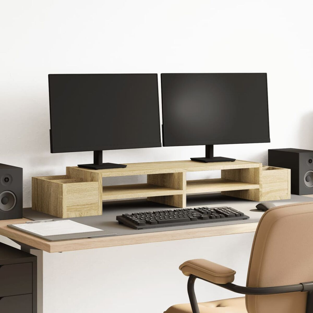 Computertisch mit zwei Monitoren, Tastatur, Lautsprechern und Zubehör. Hintergrund: weiße Wand.